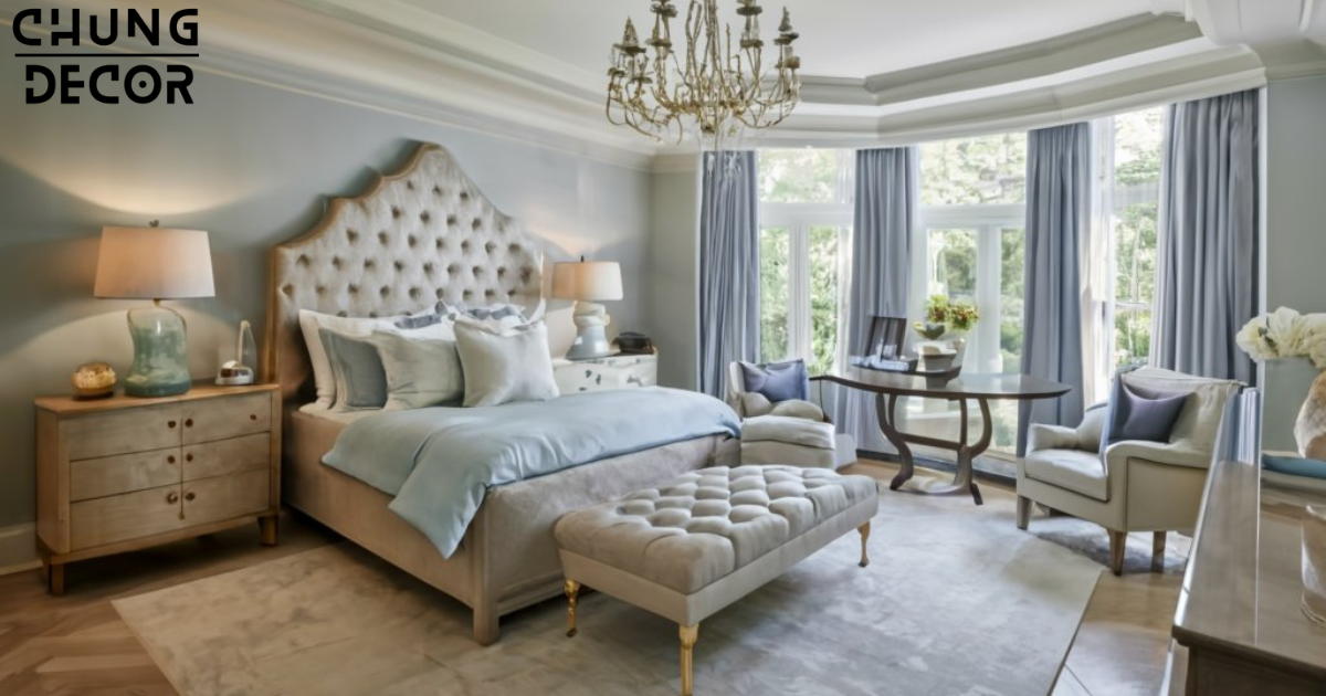 A serene mansion bedroom decorated in a harmonious color scheme of soft blues and creamy whites. The walls are painted a pale blue hue, providing a soothing backdrop for the elegant furnishings and decor. A plush area rug in shades of ivory and light gray anchors the space, while metallic accents in gold and silver add a touch of glamour.