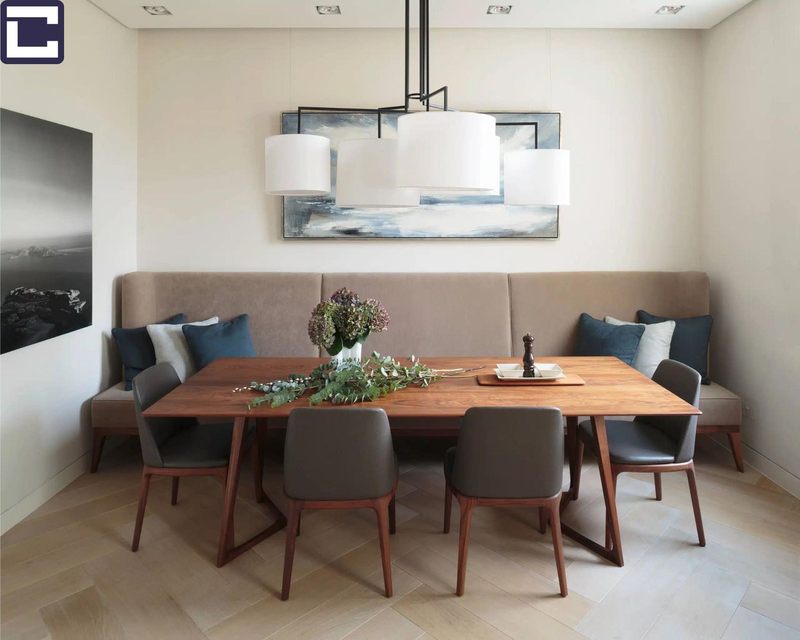 An image illustrating a living room-dining room combo furnished with multifunctional pieces. A dining table, possibly extendable or with foldable leaves, serves as a workspace during the day and transforms into a dining spot in the evening. Surrounding the table are versatile chairs that provide comfortable seating for both dining and lounging. Additionally, storage ottomans are strategically placed to offer extra seating while concealing blankets or board games within. The efficient use of multifunctional furniture maximizes space in the compact room.