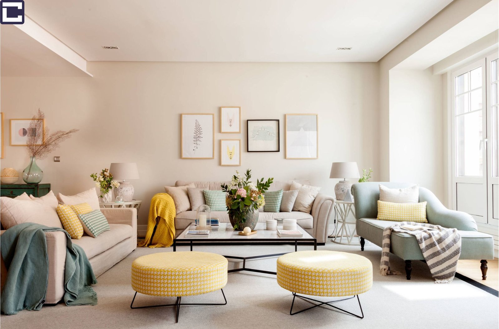 The image showcases a living room adorned in modern chic decor, featuring a harmonious balance of elements that create a cohesive and inviting ambiance. A neutral color palette of soft greys and warm creams sets the tone for the room, creating a serene backdrop for the furniture and decor. A plush sofa and armchair with clean lines provide comfortable seating, while a sleek coffee table and minimalist side table add functionality without overwhelming the space. Above, a statement chandelier with a geometric design casts a warm glow over the room, adding visual interest and depth. Large windows allow natural light to flood the space, further enhancing the harmonious balance of the room.