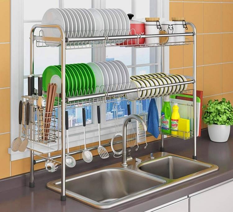 An in-sink drying rack with dishes and utensils drying inside the sink, demonstrating its space-saving design.